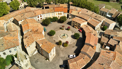 Sticker - Aerial shot of a medieval round village with red tile roofs surrounded by green fields and trees