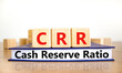 CRR cash reserve ratio symbol. Concept words CRR cash reserve ratio on wooden cubes on book on a beautiful wooden table, white background. Business and CRR cash reserve ratio concept. Copy space.