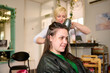 Smiling white woman getting her hair styled by a hairdresser