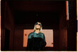 © Cavan Images - Portrait of happy blonde woman with sunglasses and dark clothes