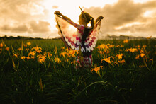 Girl Pretends To Fly With Butterfly Wings In Golden Sunset