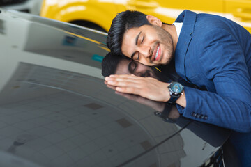 Wall Mural - Delighted arab businessman hugging car of his dream