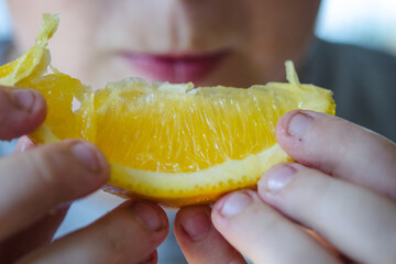 Wall Mural - closeup of an orange slice in hands