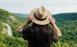 Woman in summer dress and hat travel in the mountain. Back view.