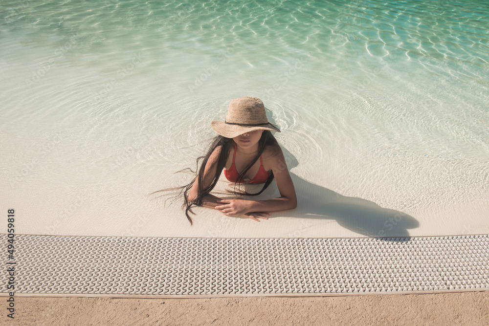 woman with hat and bikini relaxing in the swimming pool in summer Stock ...