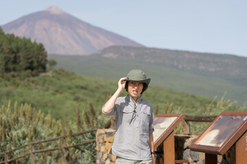 Wall Mural - A teenager stands on an observation deck high in the mountains. In the background is the Teide volcano. Tenerife. Canary Islands. Spain.