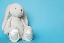 Stuffed Bunny On Blue Background. Easter Concept. Beaytiful White Toy Soft Bunny Sitting On Colored Background. Copy Space For Text