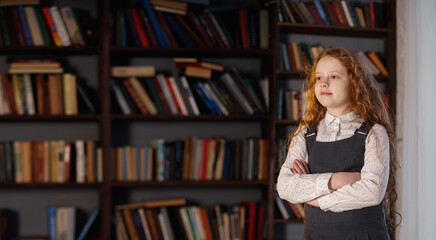 Wall Mural - Girl in the library near the shelf with books.