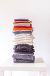 © pictures_for_you - Stack of folded colorful clothes on white background.