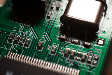 Canvas Print - Macro photo of a green computer printed circuit board with selective focus on electronic components