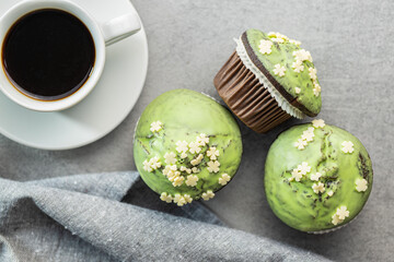 Wall Mural - Sweet muffins with pistachio icing. Sweet dessert on kitchen table.
