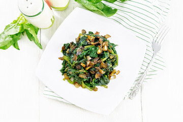 Wall Mural - Spinach fried with onions in plate on board top