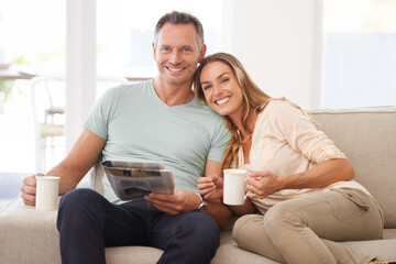 Poster - Sharing the morning paper. Portrait of a happily married couple reading the newspaper on their sofa.