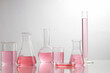 Front view of laboratory equipment filled with pink fluid in a beaker test tube in lab background for experiment advertising 