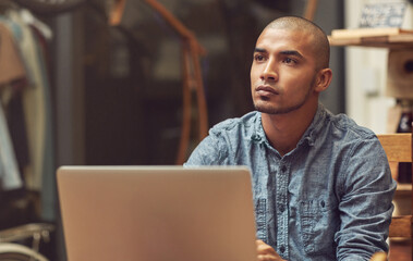 Aufkleber - His store is wifi enabled. Shot of a young man using a laptop in a cafe.