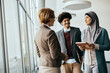 © Drazen - Young Muslim businesswoman talks with her colleagues while working in office.
