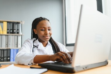 Wall Mural - happy young african female nurse working in office