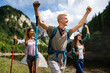 © NDABCREATIVITY - Group of smiling friends hiking with backpacks outdoors. Travel, tourism, hike and people concept.