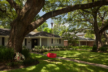Red Tire Swing Hanging From A Tree At The Detached Residential House Garden In Afton Oaks, Houston 
