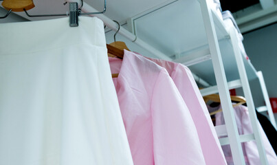 Wall Mural - Row of cloth hangers with female pink shirts