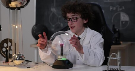 Wall Mural - physics science lab: handsome young scientist in white coat and glasses doing electrical tests. chil