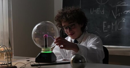 Wall Mural - physics science lab: handsome young scientist in white coat and glasses doing electrical tests. chil