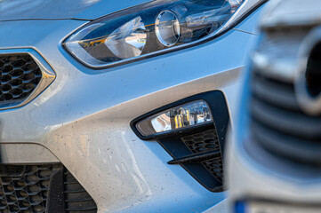 Wall Mural - Closeup of headlights of cars standing in a row, aelective focus