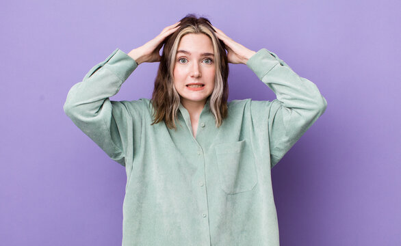 pretty caucasian woman feeling stressed, worried, anxious or scared, with hands on head, panicking at mistake