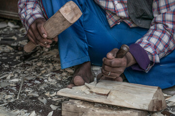 closeup hands of a local carpenter carving wooden masks or objects