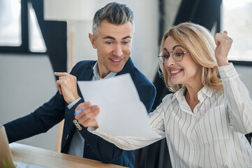 Two business colleagues discussing good news and looking excited