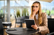© Minerva Studio - Young businesswoman on a coffee break. Using tablet computer.