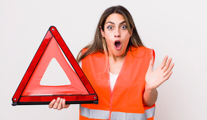 Wall Mural - pretty hispanic woman feeling extremely shocked and surprised. car triangle concept