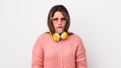 Wall Mural - pretty hispanic woman feeling disgusted and irritated and tongue out. headphones concept