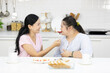 © offsuperphoto - mother feeding apple to down syndrome teenage girl or her daughter, and eating breakfast together in the kitchen