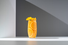 Glass of refreshing orange drink served on white table