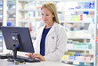 © Yuri A/peopleimages.com - We monitor every customers history. Shot of an attractive pharmacist using a computer.