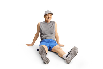 Elderly man in sportswear sitting on floor and resting