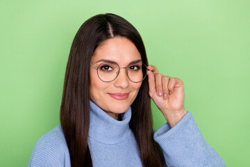 Poster - Photo of optimistic young brunette lady hand spectacles wear blue sweater isolated on green color background