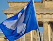 Flagge mit Friedenstaube vor dem Brandenburger Tor in Berlins 