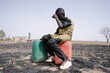 African teenager strained for walking long distance to collect clean water. Water scarcity symbol.