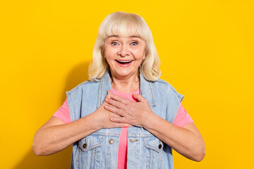 Sticker - Photo of impressed funny retired woman wear jeans vest arms chest open mouth isolated yellow color background