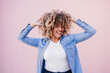 © Eva - portrait of beautiful curvy hispanic woman, afro hair outdoors in spring. pink wall. Body positivity