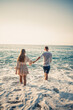 © DSMT - Happy couple by the sea. Honeymoon lovers. Man and woman on the island. Beautiful couple having fun on the seashore. Happy couple on vacation. Man and woman by the sea.