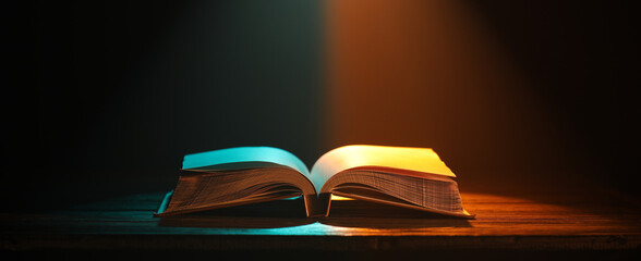 Wall Mural - Open book on wooden table against dark background