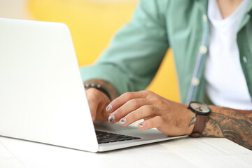 Wall Mural - Man with stylish manicure working on laptop, closeup