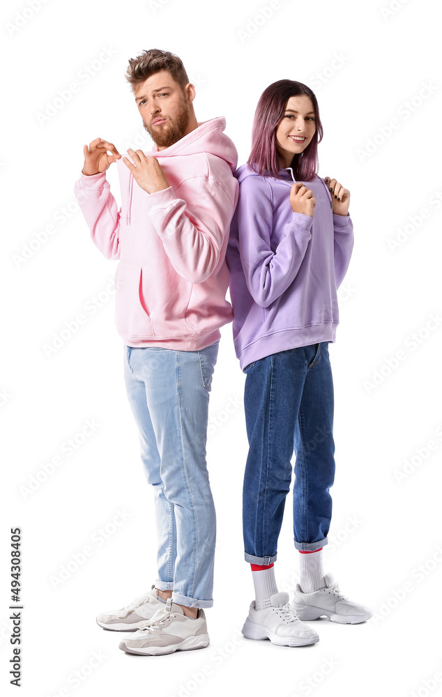 Cool young couple in hoodies on white background