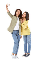 Canvas Print - Happy sisters taking selfie on white background