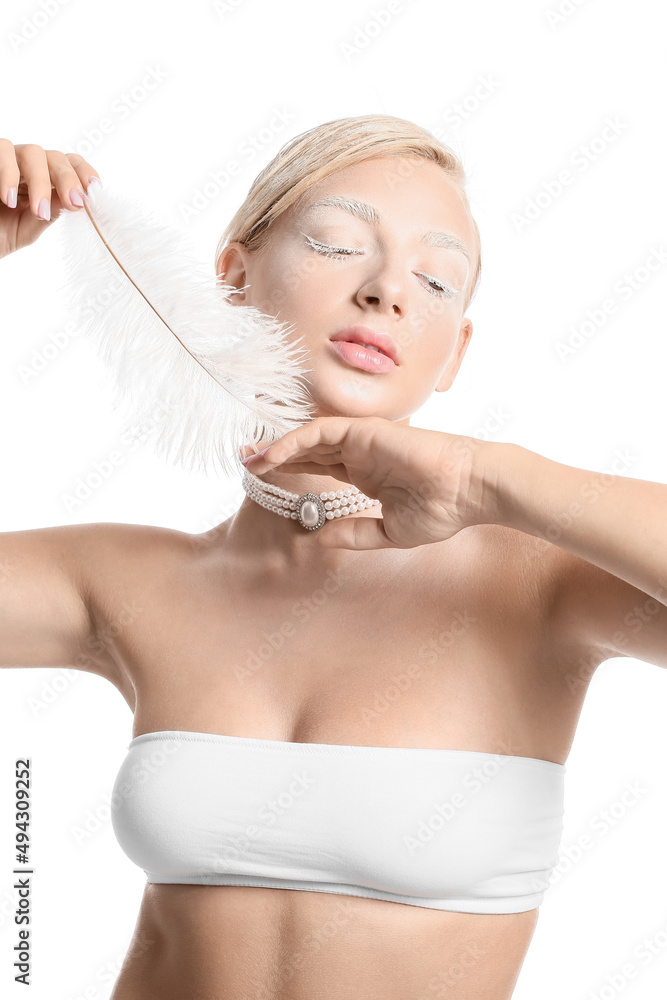 Beautiful young woman with creative makeup and feather on white background