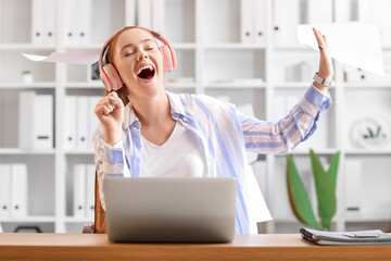 Wall Mural - Emotional young woman listening to music in office