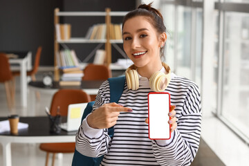 Beautiful female student with mobile phone in library
